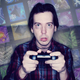 A tired man plays games while crafting materials float behind him.